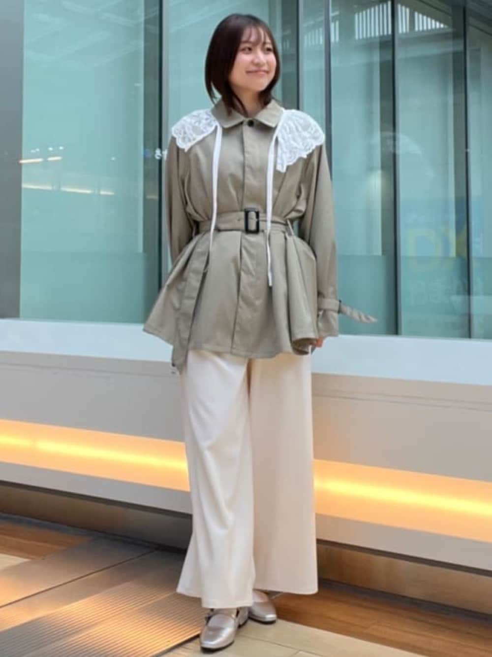 グリーン系のトレンチコートを着用したレディースの冬コーディネートの3枚目の写真