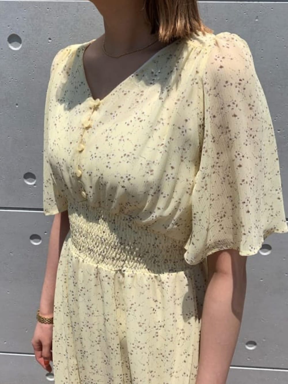 イエロー系のワンピース、ホワイト系のサンダルを着用したレディースの夏コーディネートの2枚目の写真