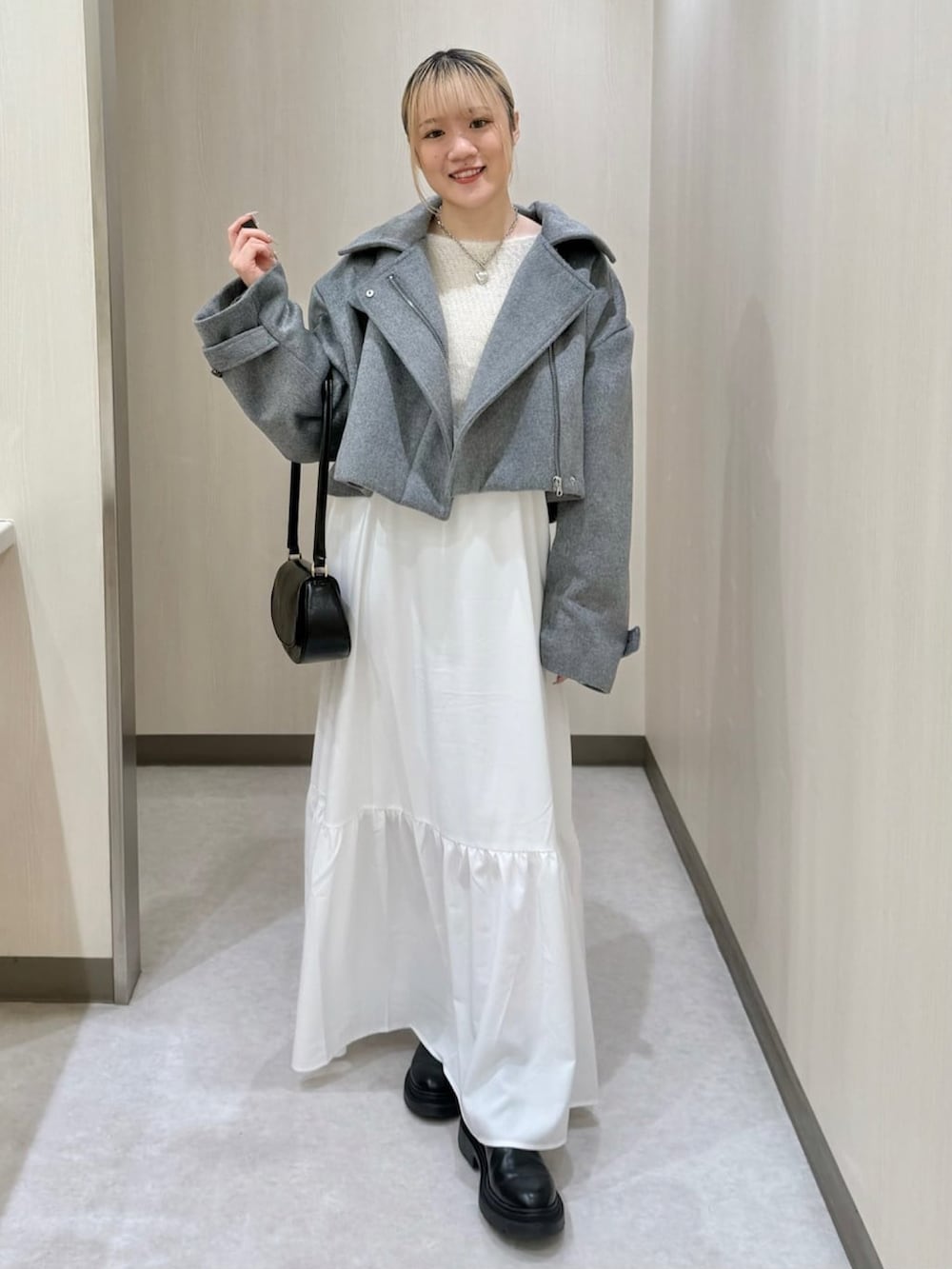 グレー系のその他アウター、ホワイト系のワンピース、ブラウン系のショルダーバッグを着用したレディースの冬コーディネートの2枚目の写真