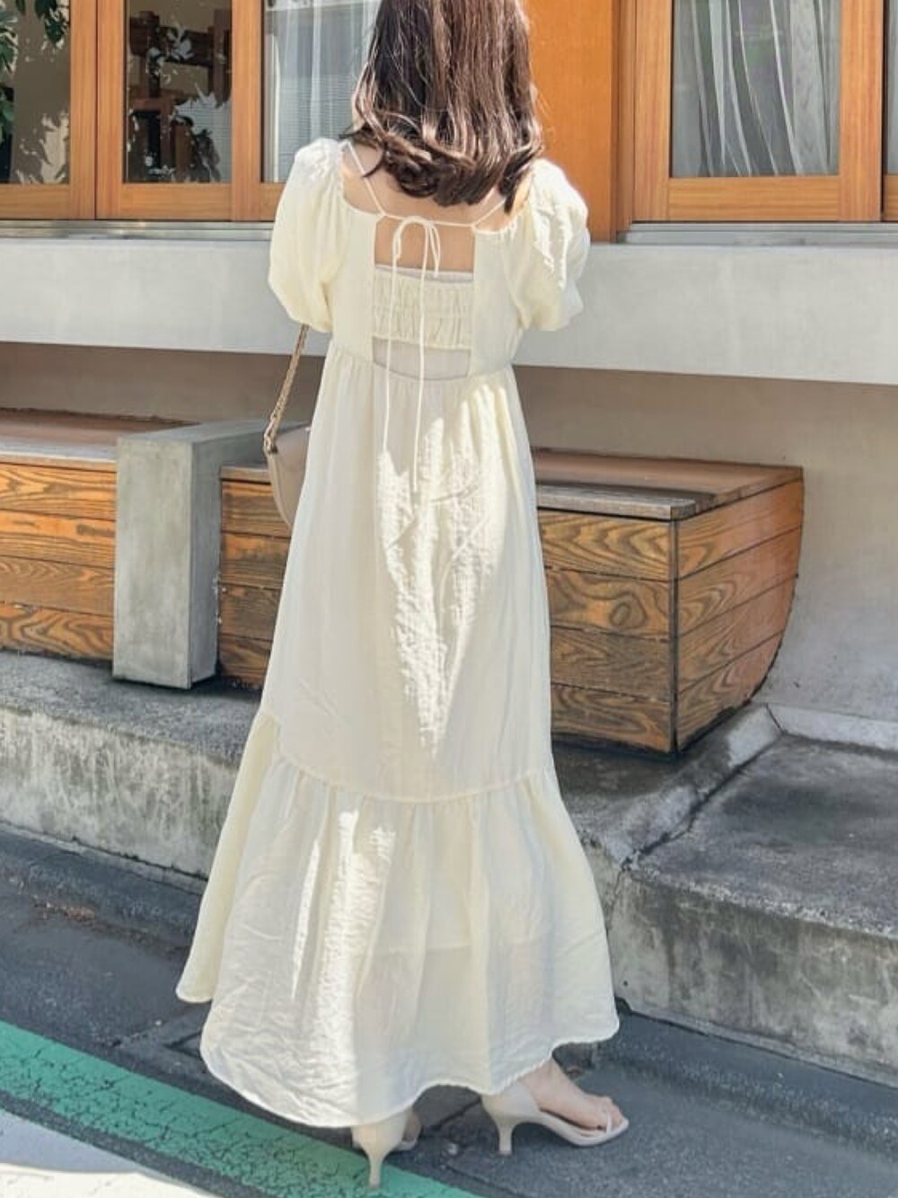 ブラック系のサンダル、ホワイト系のワンピースを着用したレディースの夏コーディネートの2枚目の写真