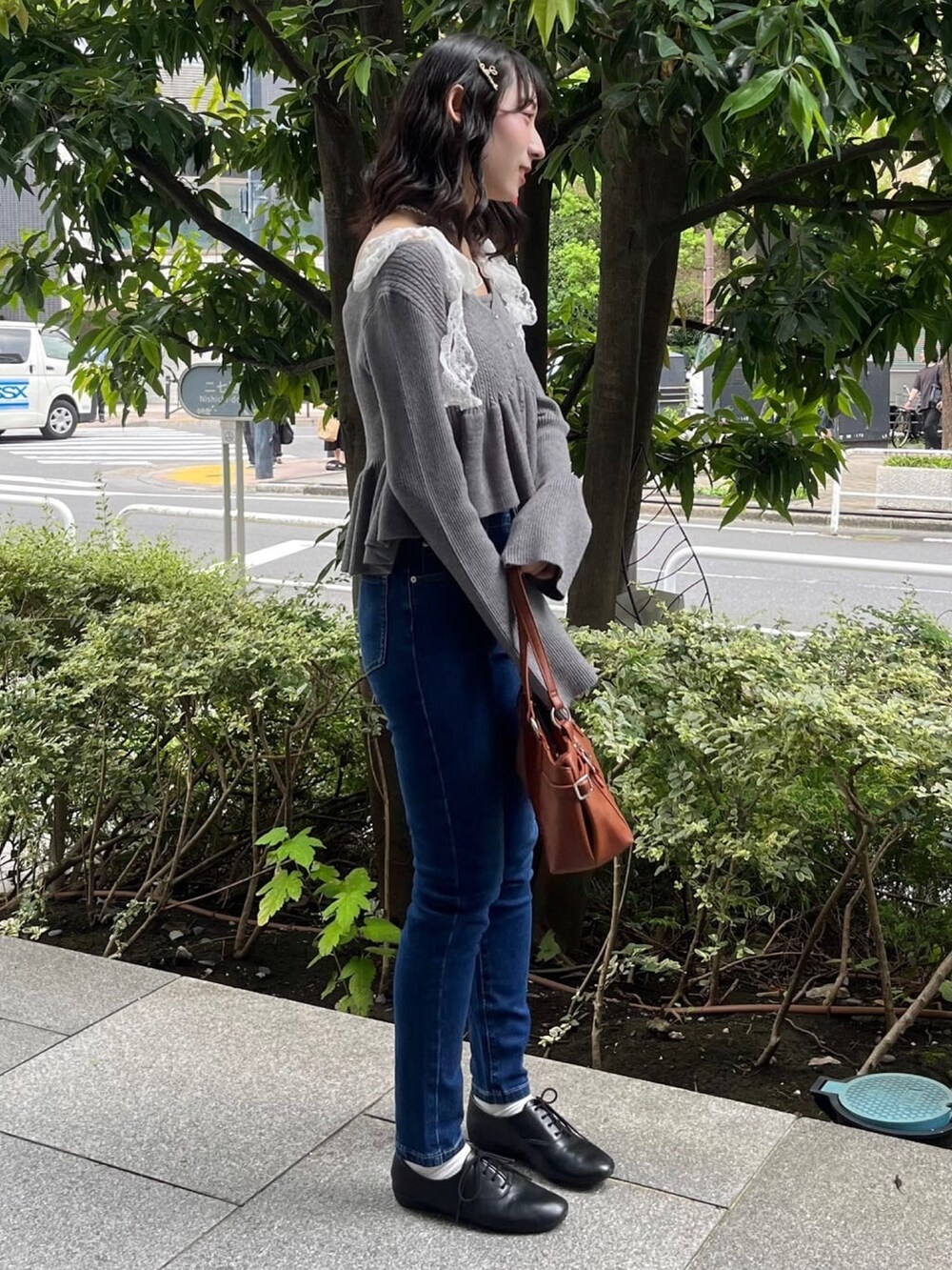 グレー系のアンサンブル、ブルー系のデニムパンツを着用したレディースの秋コーディネートの2枚目の写真