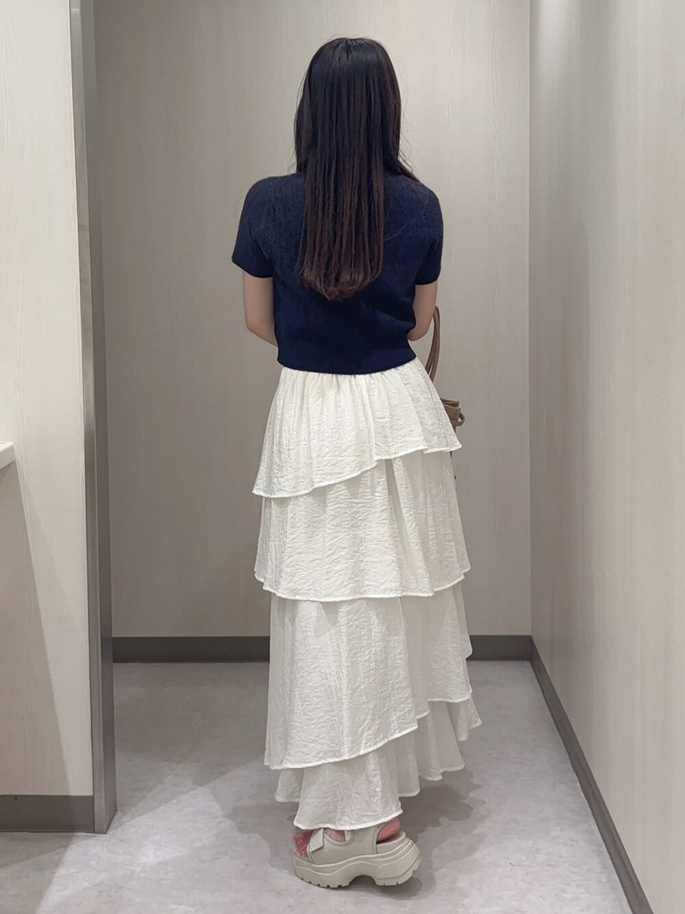 ホワイト系のスカートを着用したレディースの夏コーディネートの2枚目の写真