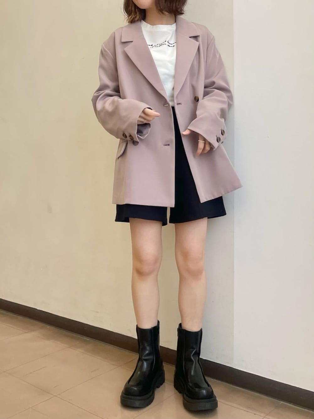 ピンク系のテーラードジャケット、ブラック系のブーツを着用したレディースの春コーディネートの3枚目の写真