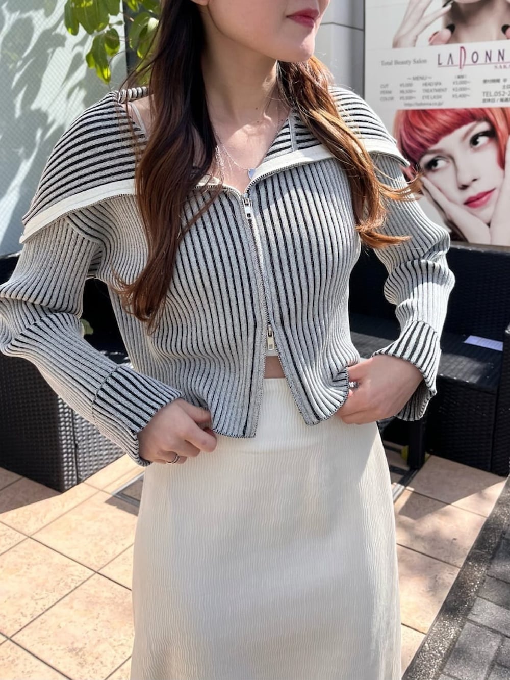 ホワイト系のスカート、グレー系のパンプス、ブルー系のニット/セーターを着用したレディースの春コーディネートの3枚目の写真