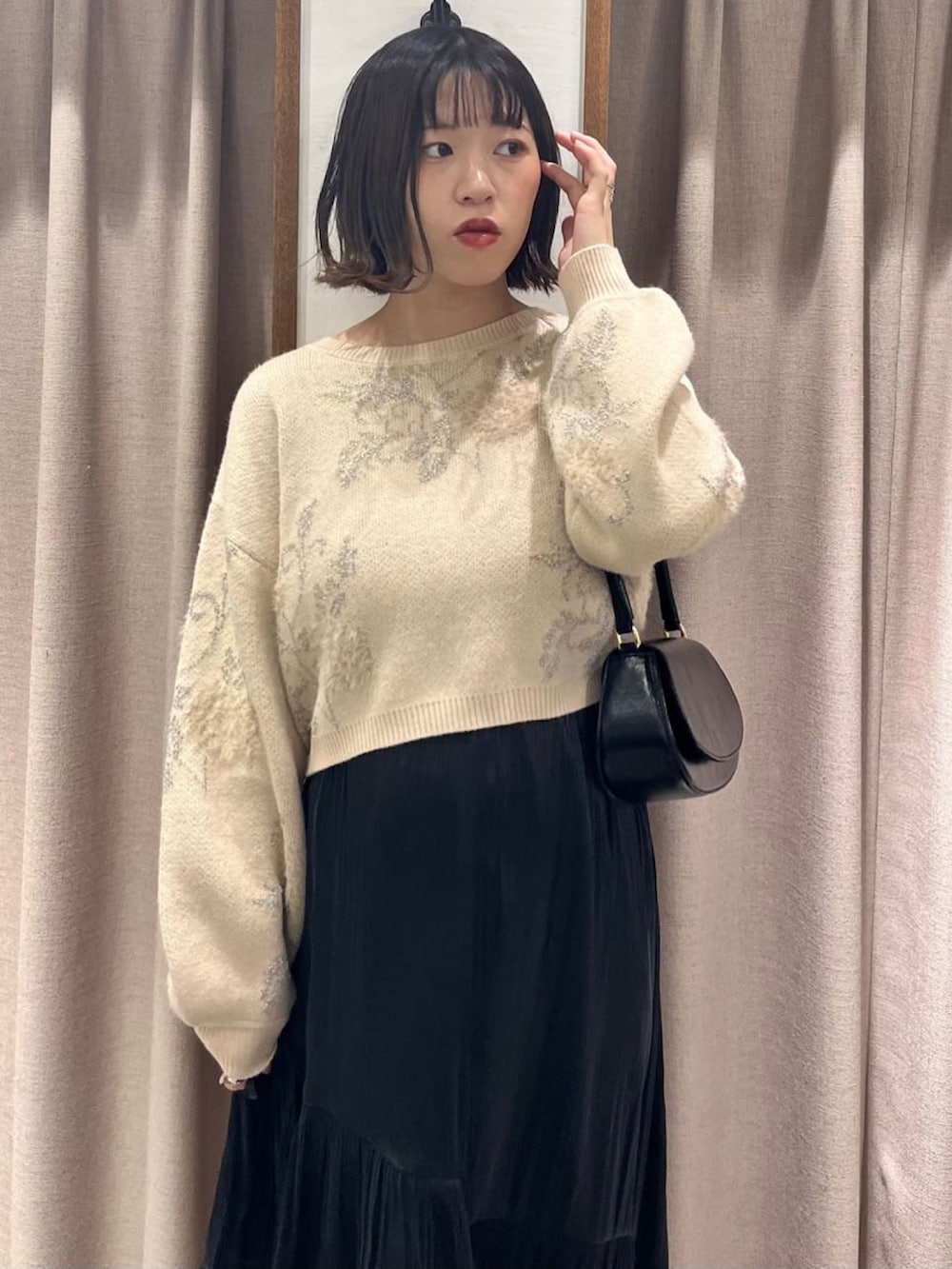 ホワイト系のニット/セーター、ブラック系のスカート、ホワイト系のショルダーバッグを着用したレディースの冬コーディネートの2枚目の写真