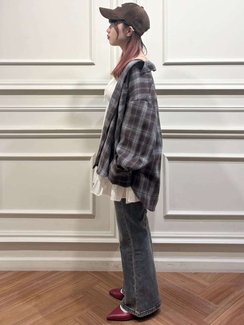 ブラウン系のシャツ/ブラウス、ブルー系のデニムパンツ、ホワイト系のチュニックを着用したレディースの秋コーディネートの2枚目の写真