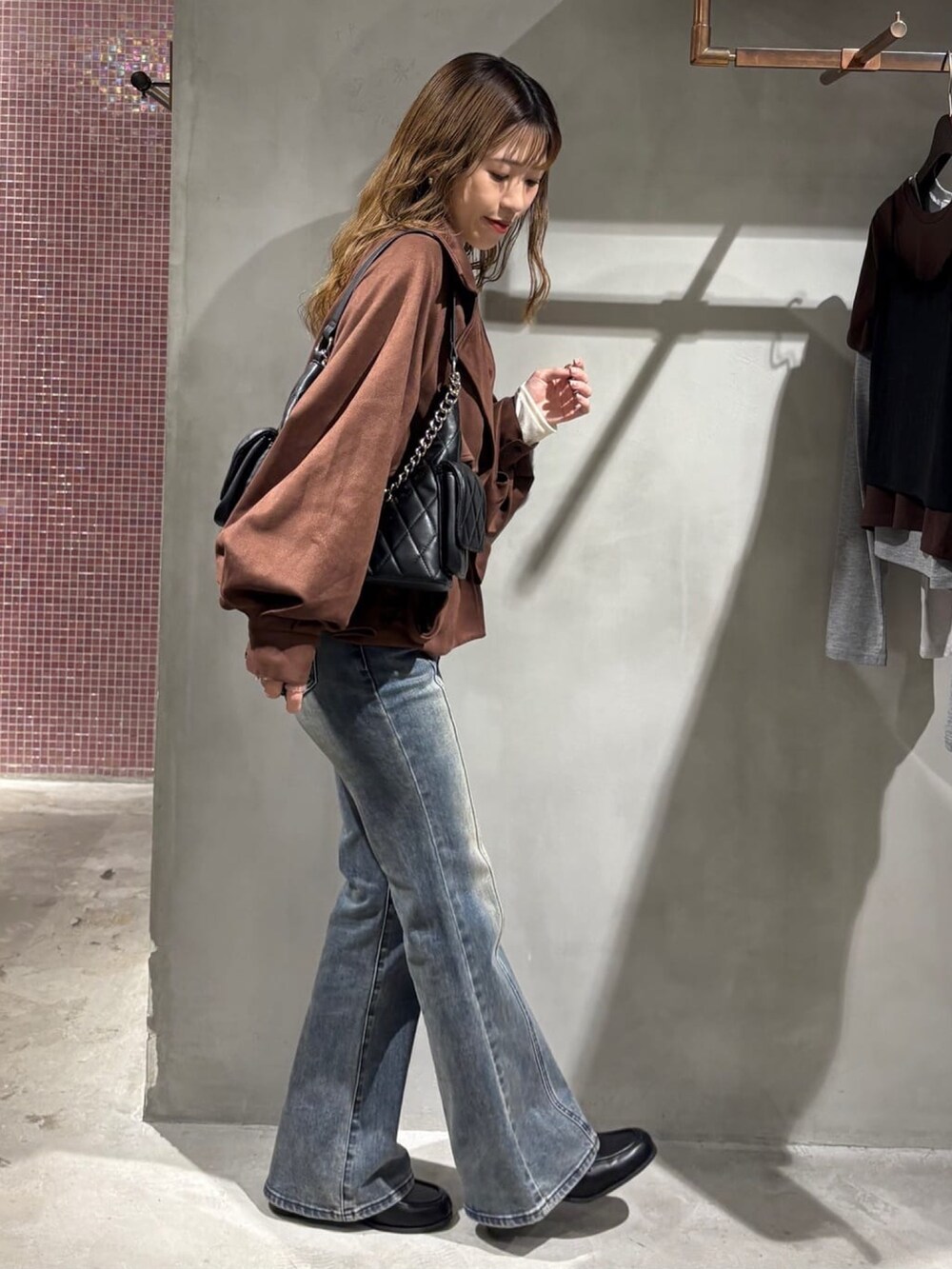 ベージュ系のTシャツ/カットソー、ブルー系のブルゾン、ブラック系のショルダーバッグを着用したレディースの秋コーディネートの2枚目の写真