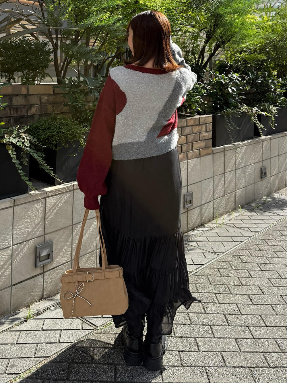 レッド系のTシャツ/カットソー、ブラック系のスカートを着用したレディースの秋コーディネートの3枚目の写真