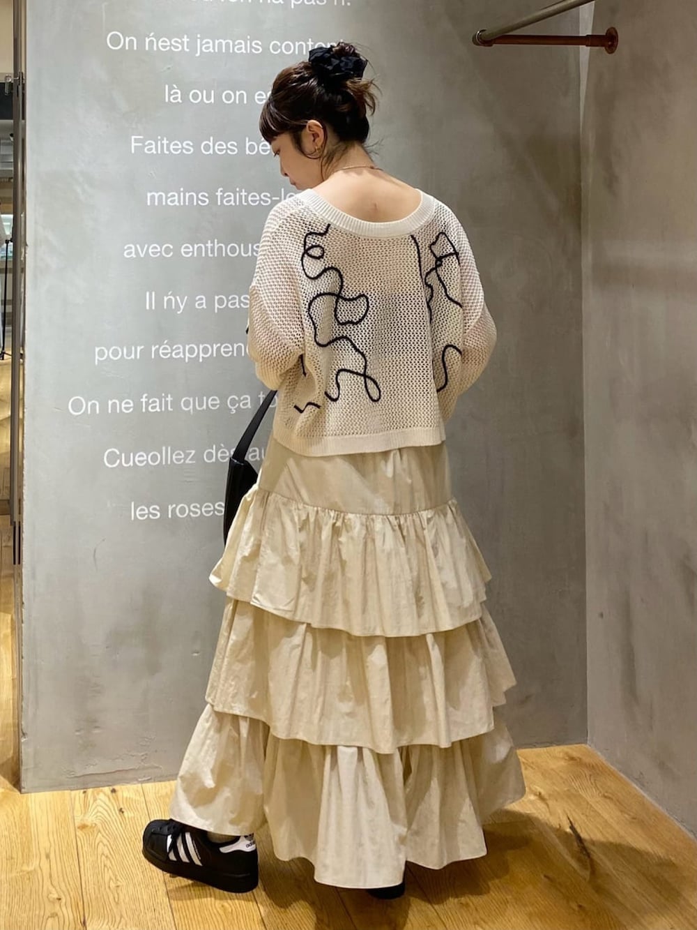 ホワイト系のカーディガン/ボレロ、ベージュ系のスカートを着用したレディースの春コーディネートの2枚目の写真