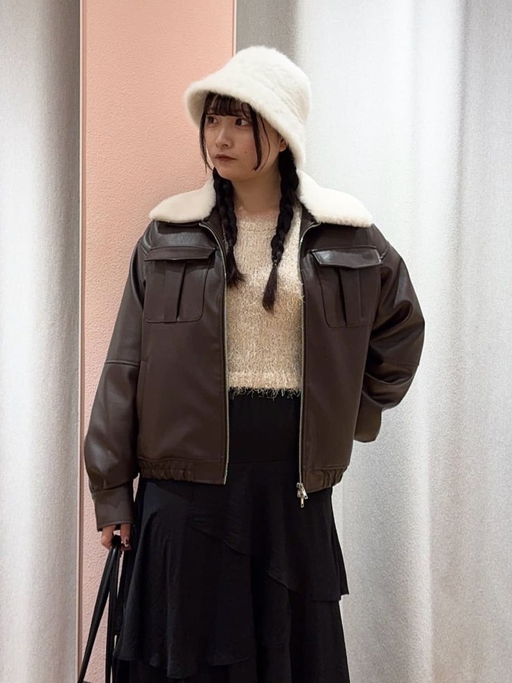 ホワイト系のニット/セーター、ブラウン系のブルゾン、ブラック系のスカートを着用したレディースの冬コーディネートの2枚目の写真