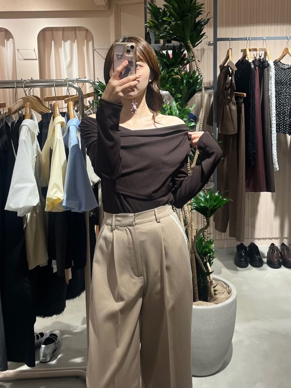 ブラウン系のTシャツ/カットソー、ブラック系のトートバッグ、ベージュ系のスラックスを着用したレディースの秋コーディネートの2枚目の写真
