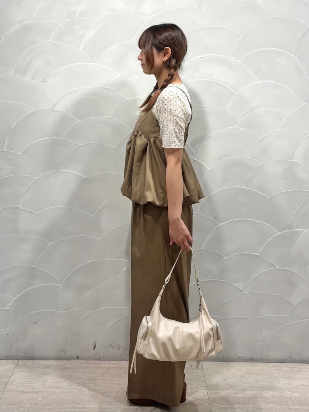 ベージュ系のパンツドレス、ホワイト系のショルダーバッグ、ホワイト系のTシャツ/カットソーを着用したレディースの夏コーディネートの2枚目の写真