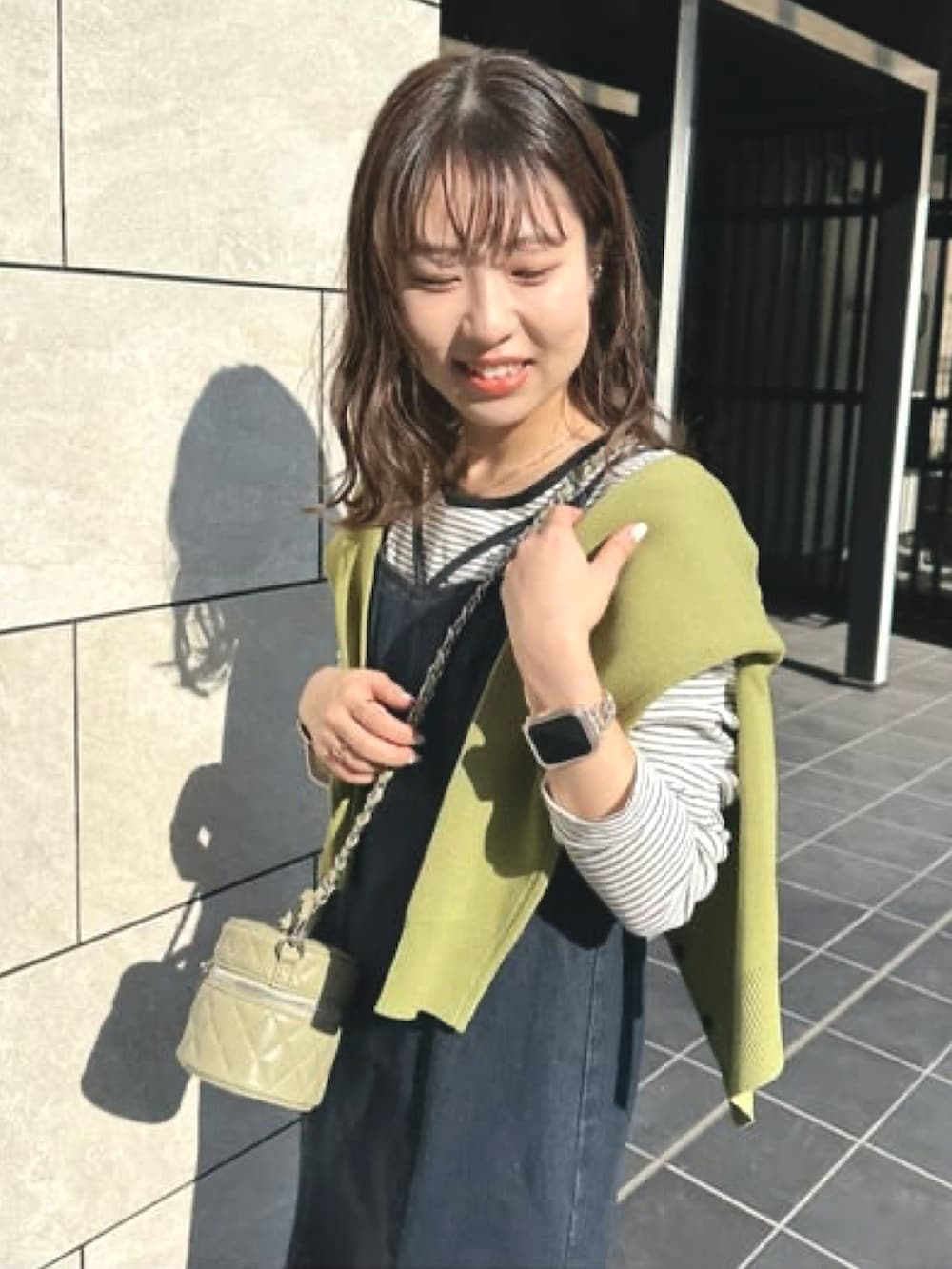 グリーン系のカーディガン/ボレロ、ブルー系のワンピース、グリーン系のショルダーバッグを着用したレディースの冬コーディネートの3枚目の写真