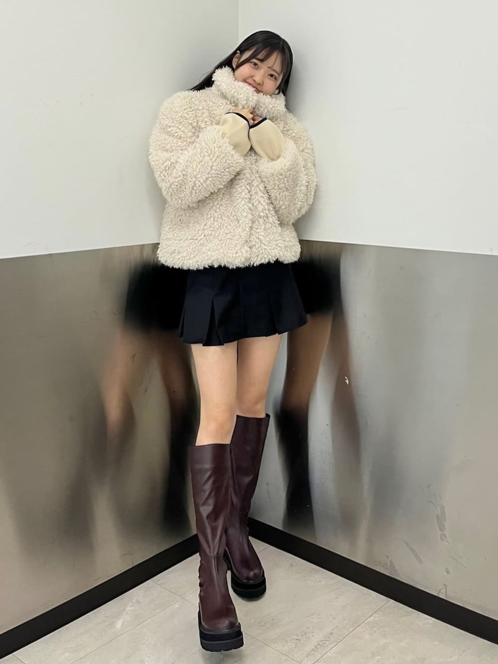 ホワイト系のその他アウター、ベージュ系のスカート、ブラウン系のブーツを着用したレディースの冬コーディネートの2枚目の写真