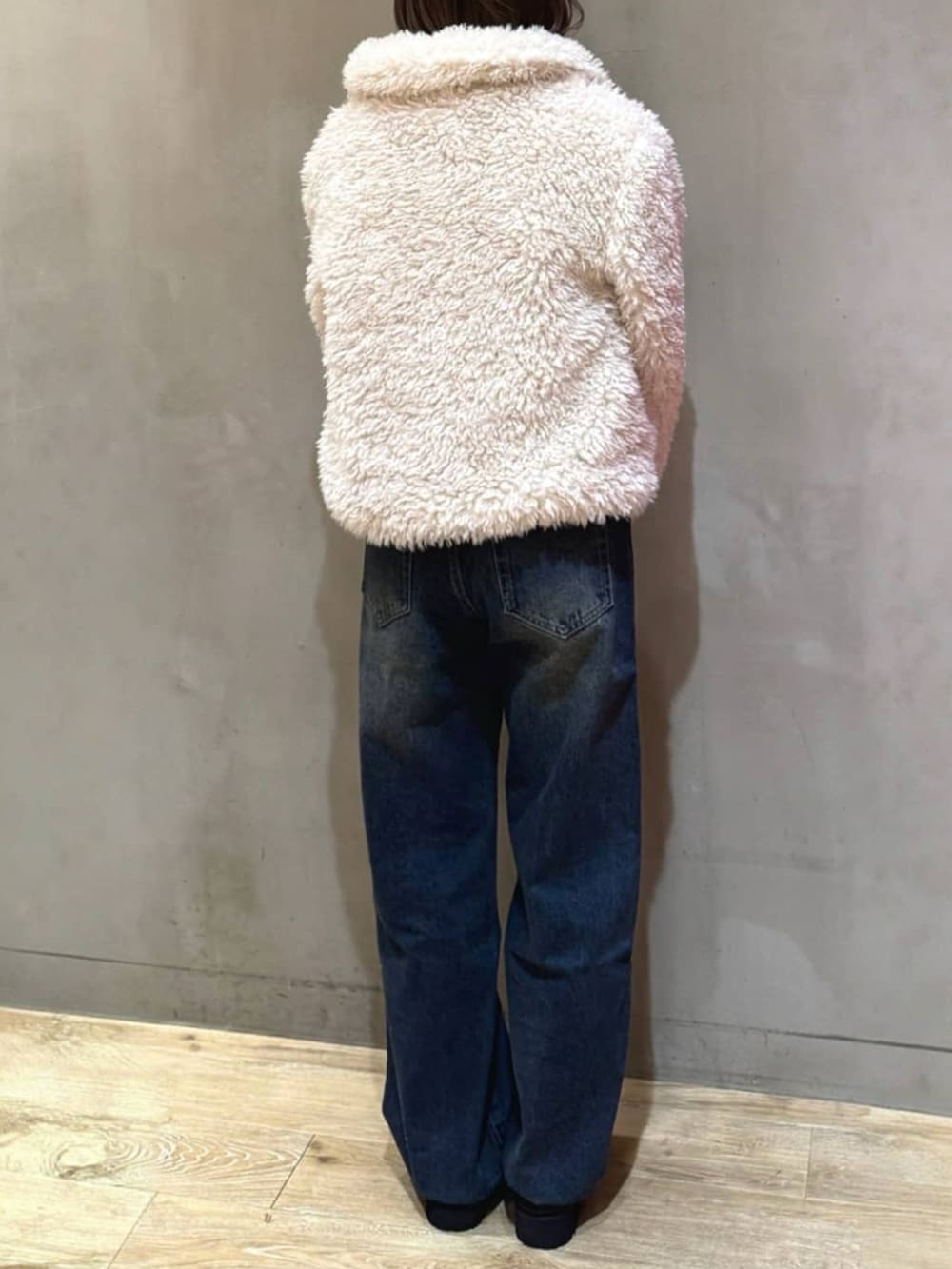 ホワイト系のブルゾン、ブルー系のデニムパンツ、ブラック系のローファーを着用したレディースの秋コーディネートの3枚目の写真