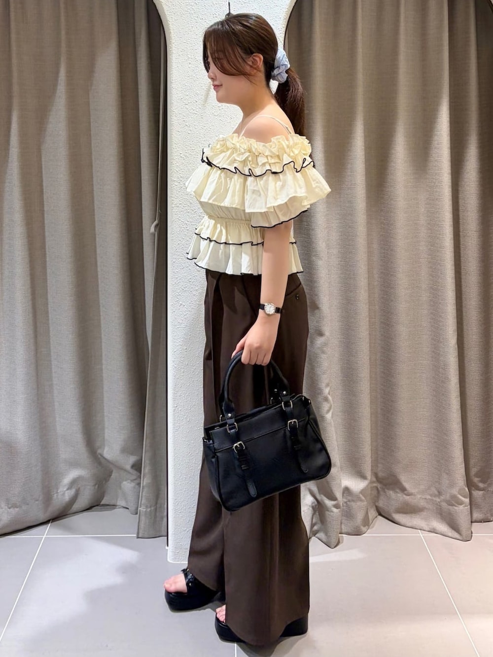 ホワイト系のシャツ/ブラウス、ブラック系のショルダーバッグ、ブラウン系のスラックスを着用したレディースの夏コーディネートの2枚目の写真