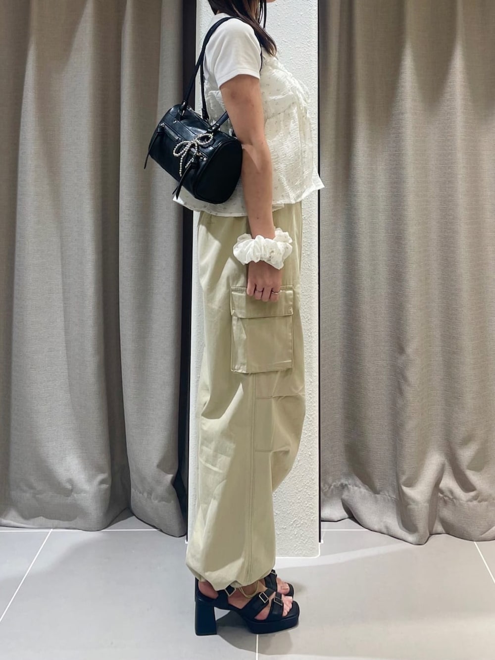 ホワイト系のアンサンブル、ベージュ系のカーゴパンツを着用したレディースの夏コーディネートの2枚目の写真