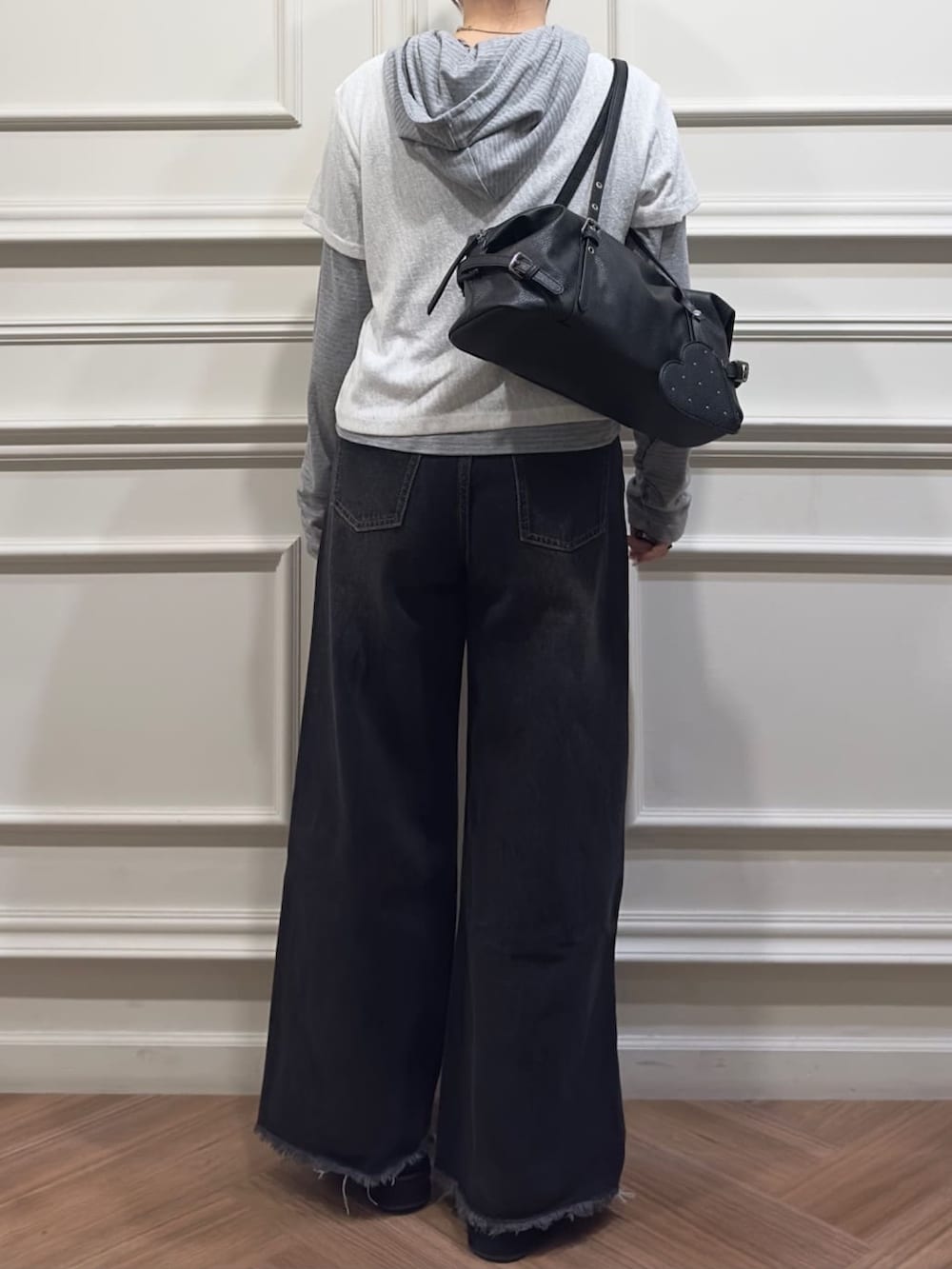 ホワイト系のTシャツ/カットソー、ブラック系のデニムパンツ、ブラック系のボストンバッグを着用したレディースの秋コーディネートの2枚目の写真