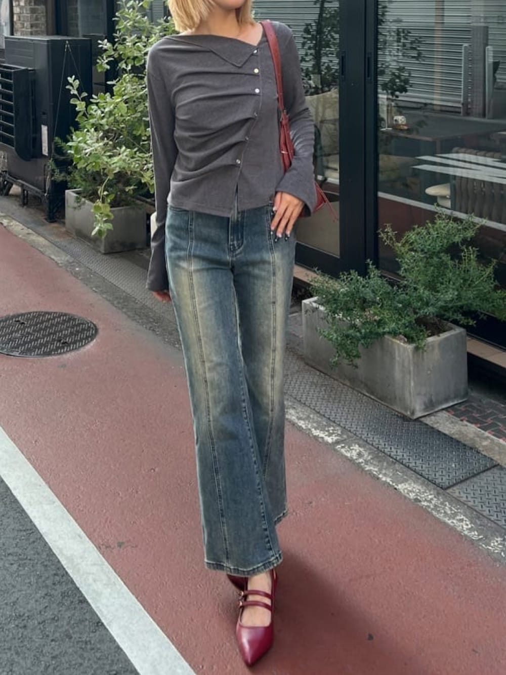 グレー系のTシャツ/カットソー、ブルー系のデニムパンツ、レッド系のパンプスを着用したレディースの秋コーディネートの3枚目の写真