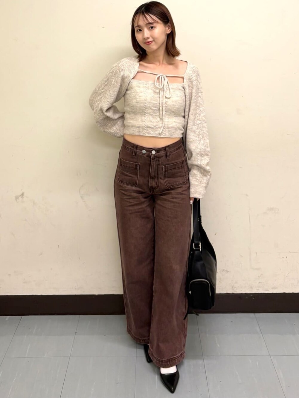ホワイト系のアンサンブル、ブラウン系のデニムパンツを着用したレディースの秋コーディネートの2枚目の写真