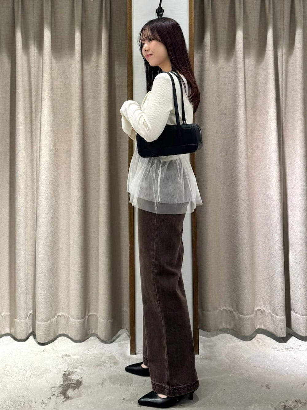 ホワイト系のアンサンブル、ブラウン系のデニムパンツ、ブラック系のパンプスを着用したレディースの夏コーディネートの2枚目の写真