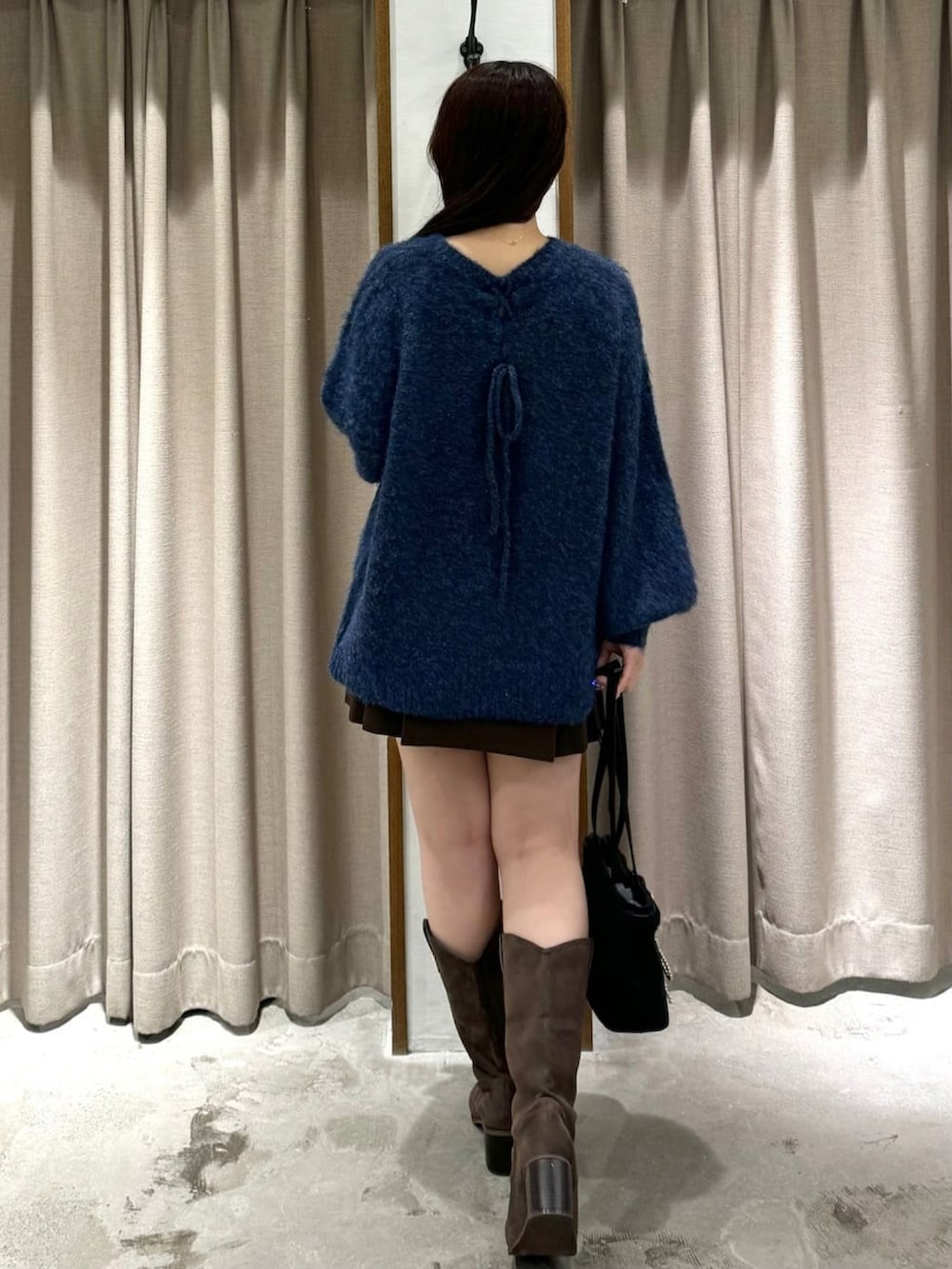 ブルー系のニット/セーター、ブラウン系のスカート、イエロー系のブーツを着用したレディースの秋コーディネートの3枚目の写真