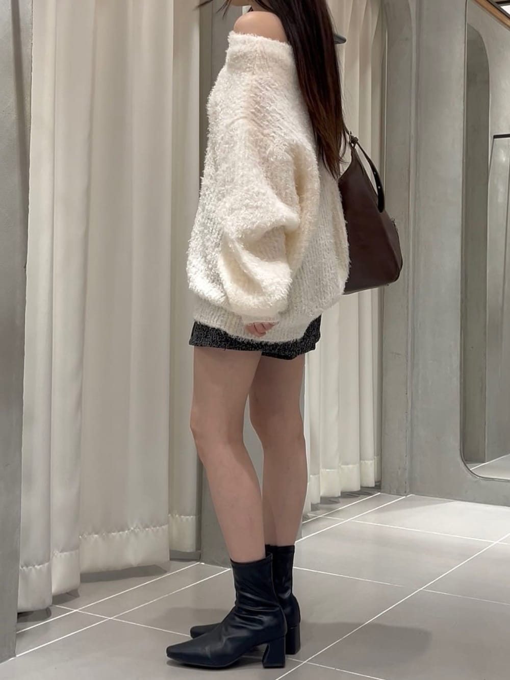 ホワイト系のニット/セーターを着用したレディースの冬コーディネートの2枚目の写真