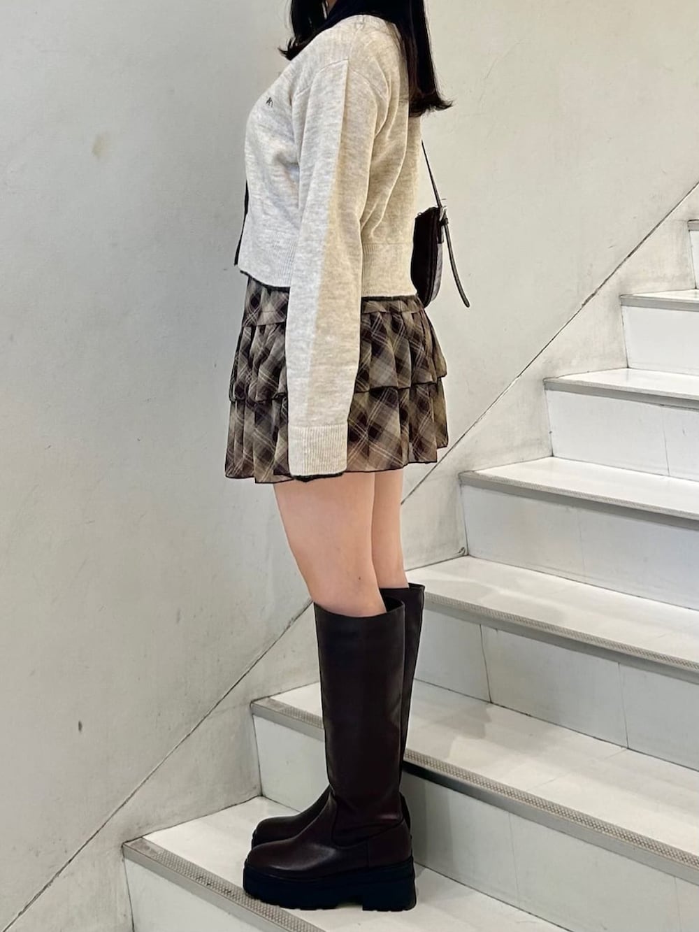 ブラウン系のアンサンブル、ブルー系のスカートを着用したレディースの秋コーディネートの3枚目の写真