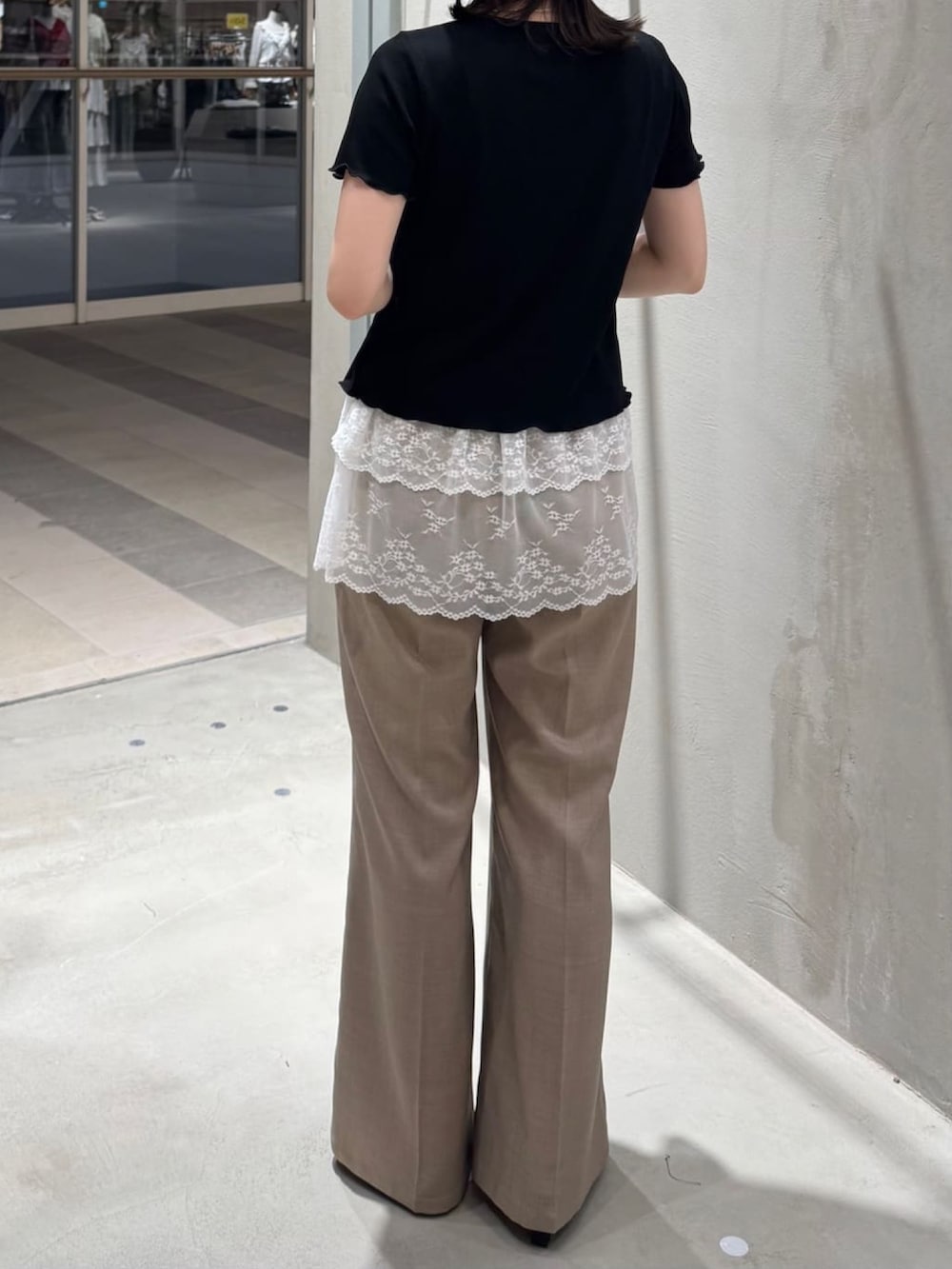 ブラック系のTシャツ/カットソー、ベージュ系のスラックスを着用したレディースの夏コーディネートの2枚目の写真