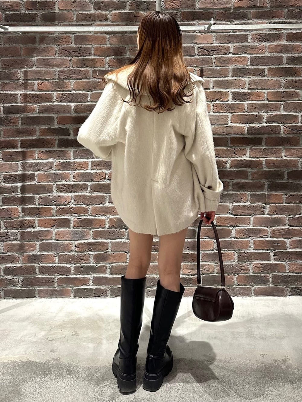 ホワイト系のショルダーバッグ、ブラック系のニット/セーター、ホワイト系のその他パンツを着用したレディースの冬コーディネートの2枚目の写真