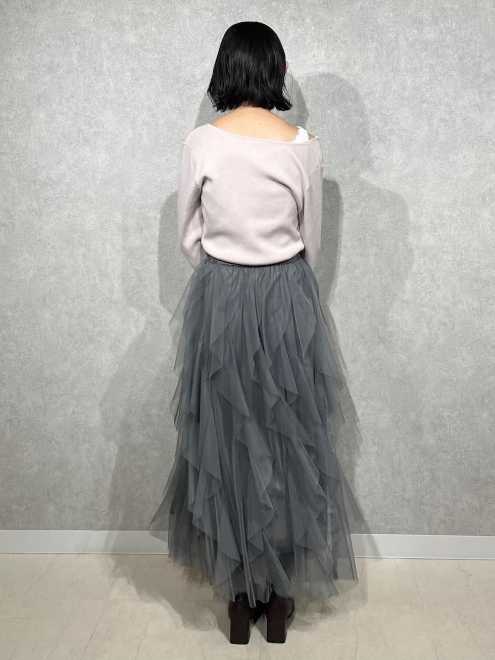 ピンク系のニット/セーター、グレー系のスカートを着用したレディースの冬コーディネートの3枚目の写真