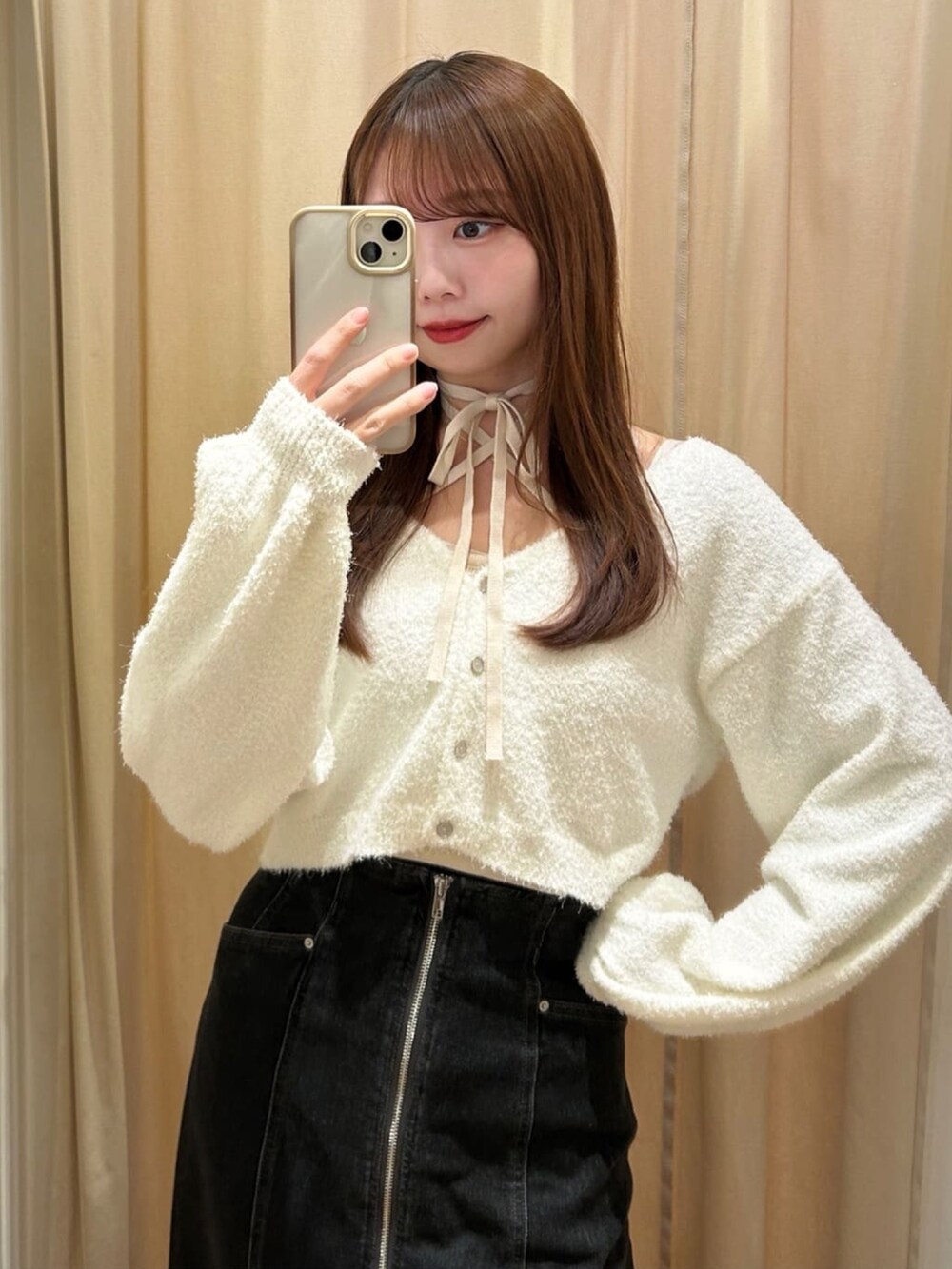 ホワイト系のニット/セーター、グレー系のスカート、ホワイト系のショルダーバッグを着用したレディースの冬コーディネートの2枚目の写真