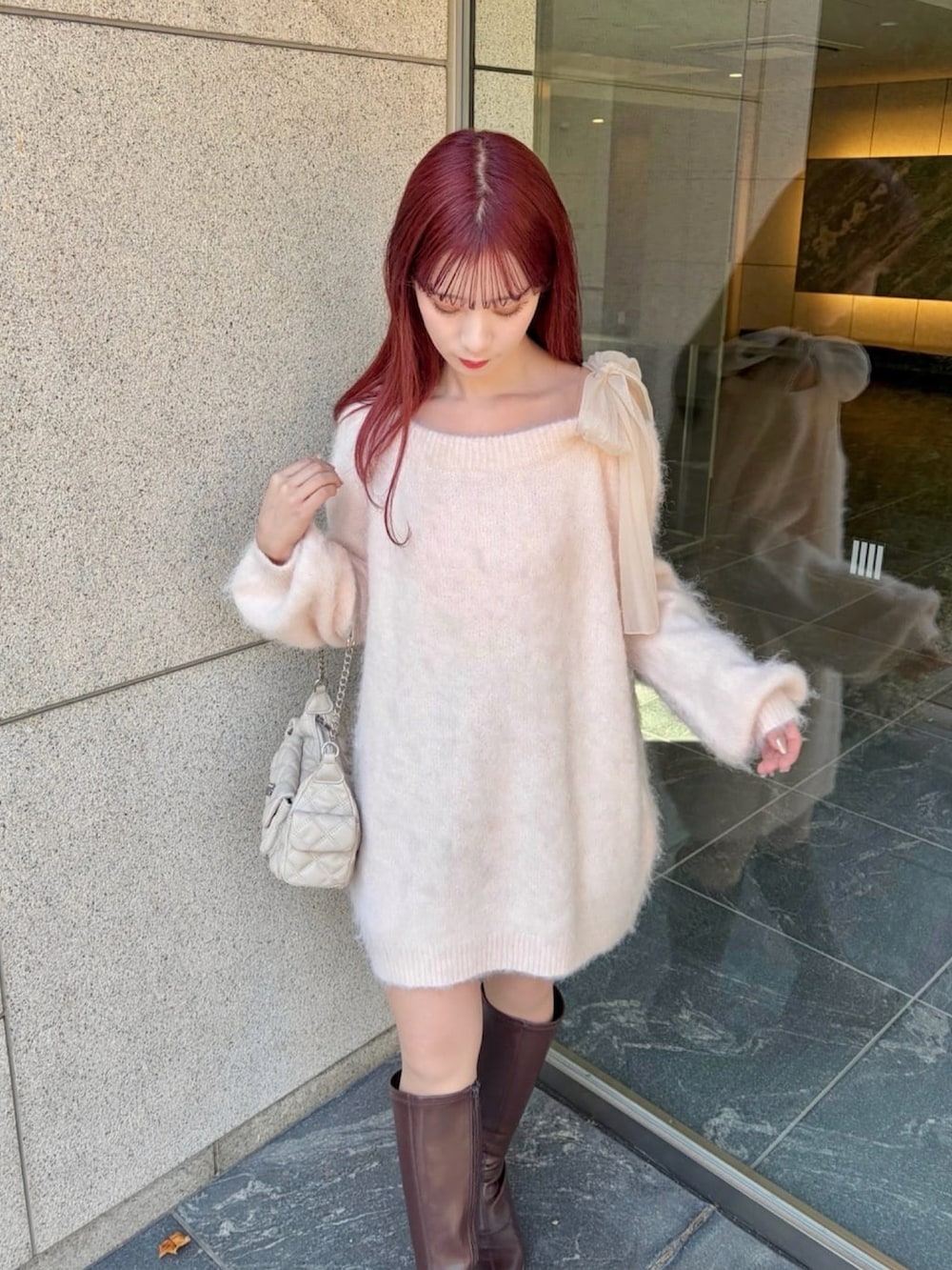 ピンク系のチュニック、ホワイト系のショルダーバッグを着用したレディースの冬コーディネートの3枚目の写真