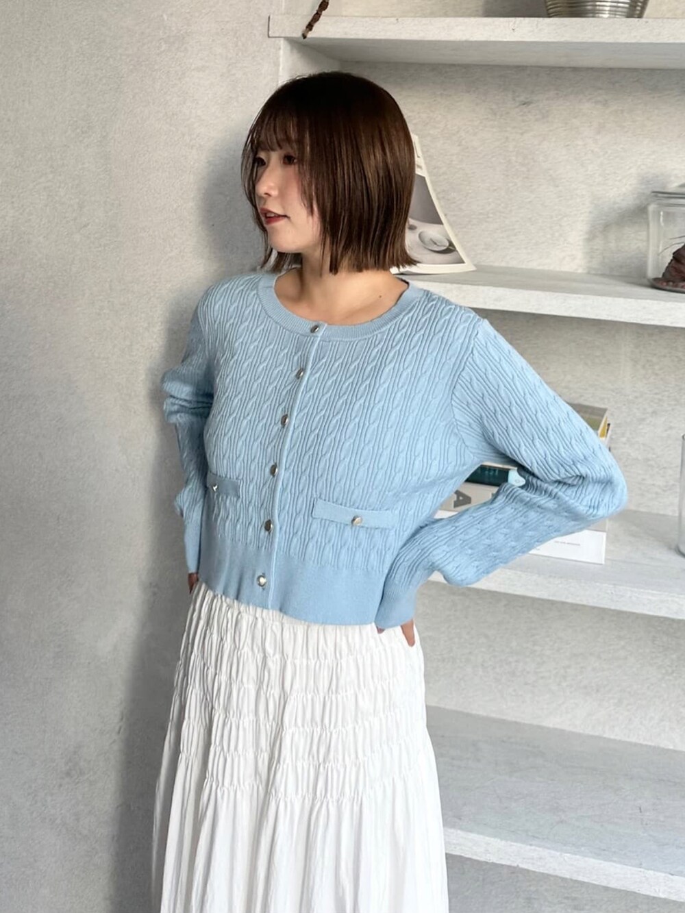 ブルー系のニット/セーター、ホワイト系のスカートを着用したレディースの冬コーディネートの2枚目の写真