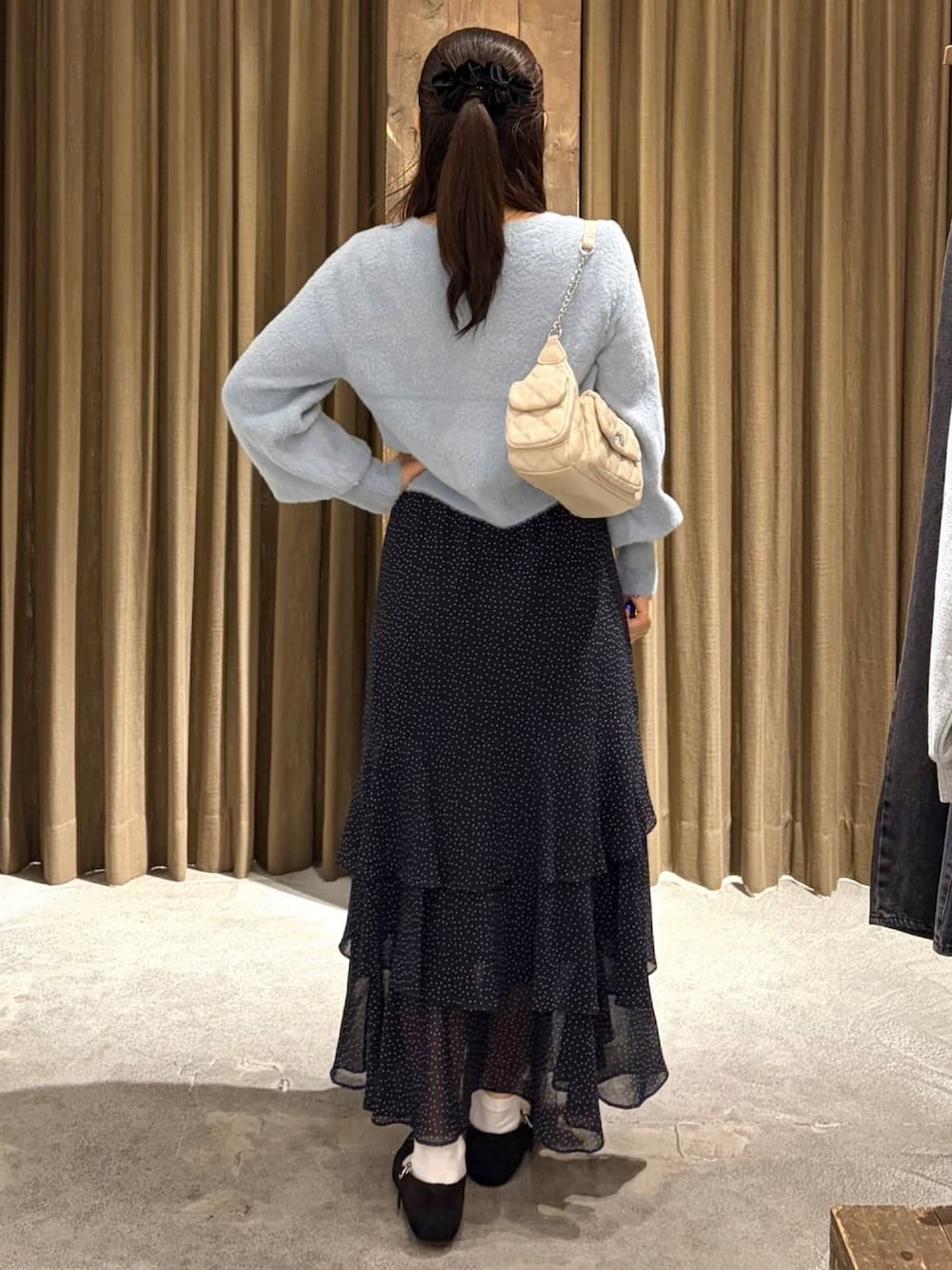 ブルー系のニット/セーター、ホワイト系のスカートを着用したレディースの秋コーディネートの3枚目の写真