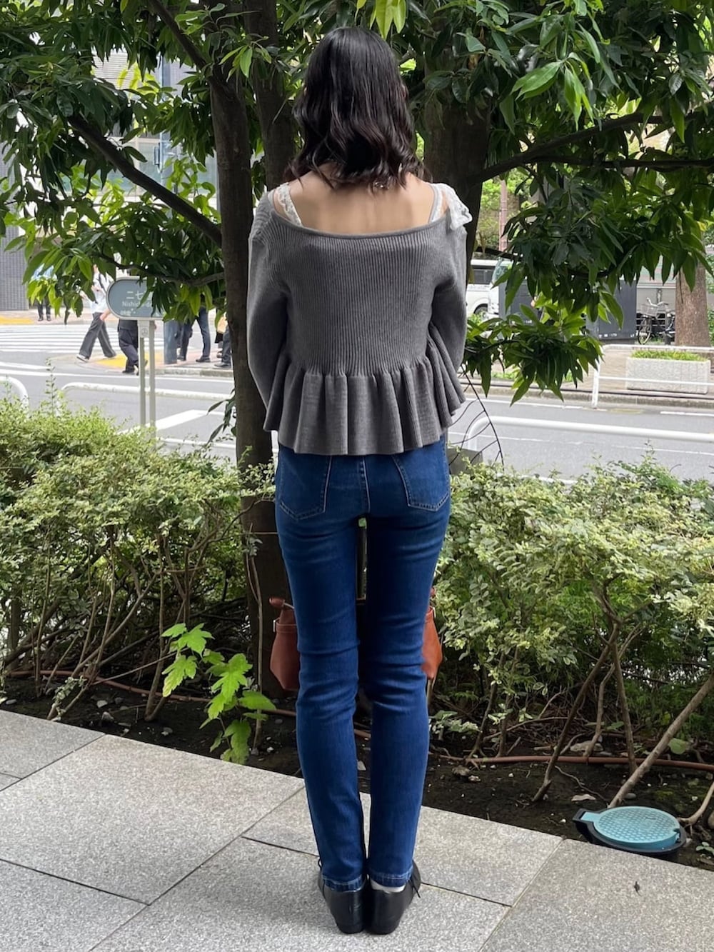 グレー系のアンサンブル、ブルー系のデニムパンツを着用したレディースの秋コーディネートの3枚目の写真