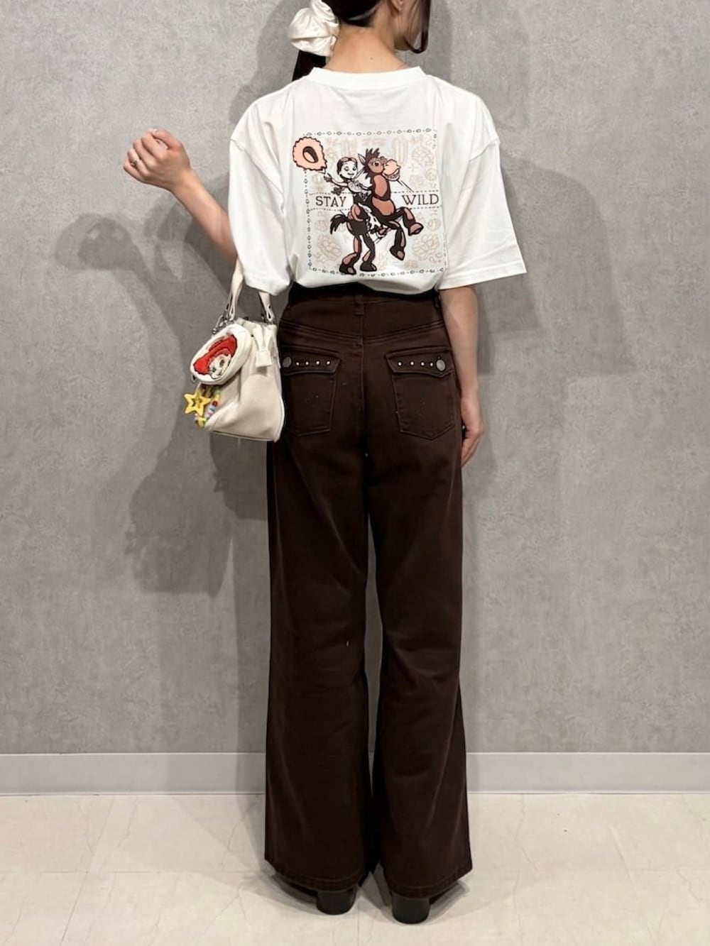 ホワイト系のTシャツ/カットソー、レッド系のTシャツ/カットソー、ブラウン系のデニムパンツを着用したレディースの夏コーディネートの3枚目の写真