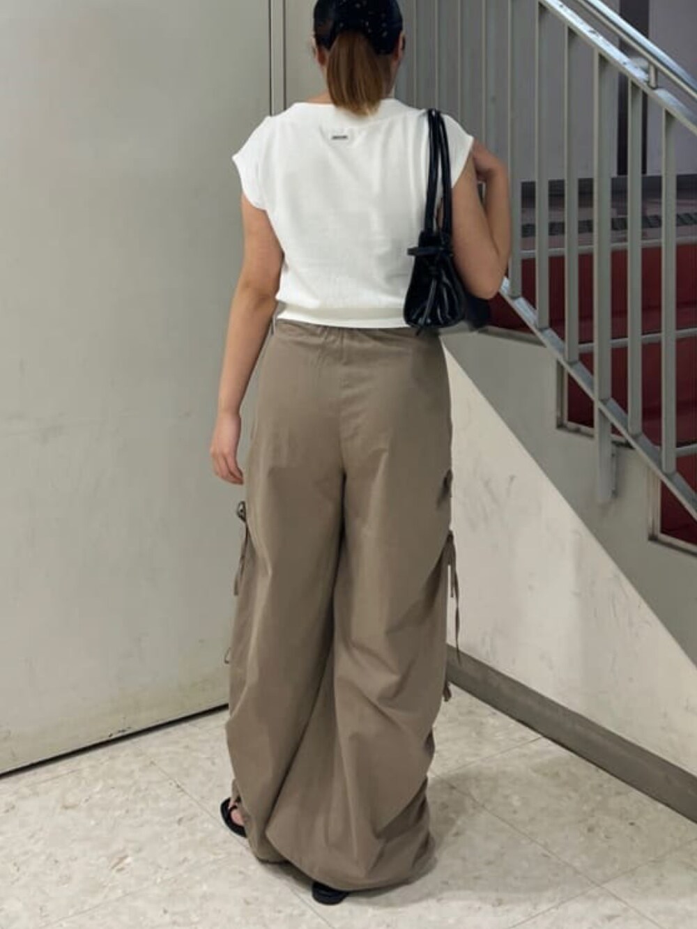 グレー系のスウェット、ベージュ系のカーゴパンツを着用したレディースの夏コーディネートの3枚目の写真