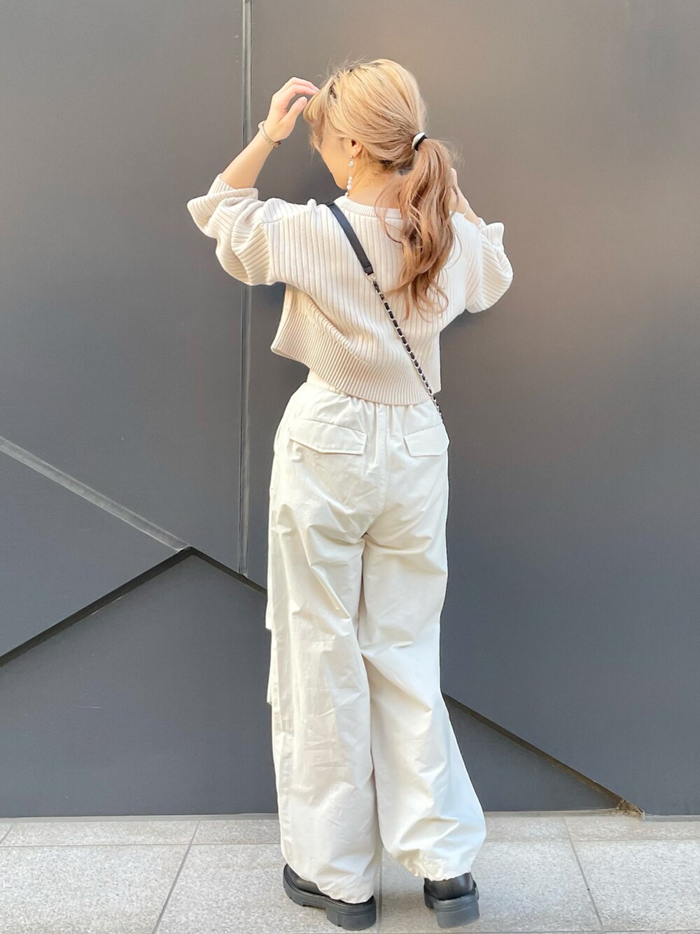 ホワイト系のカーディガン/ボレロ、ホワイト系のカーゴパンツ、ブラック系のショルダーバッグを着用したレディースの冬コーディネートの3枚目の写真