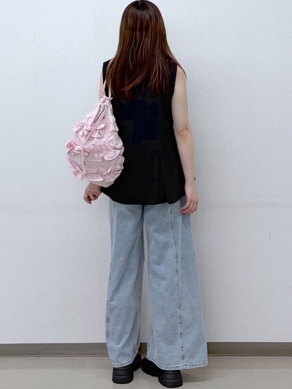 ブルー系のデニムパンツ、ブラック系のシャツ/ブラウス、ピンク系のショルダーバッグを着用したレディースの夏コーディネートの3枚目の写真