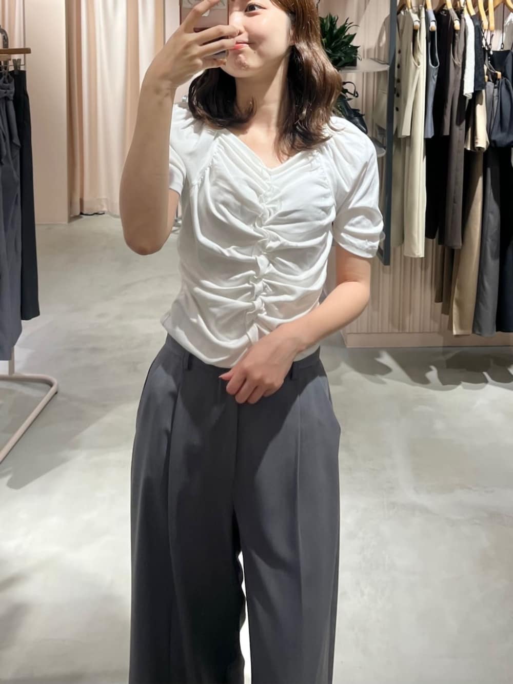 グレー系のスラックス、ブラック系のローファー、ホワイト系のTシャツ/カットソーを着用したレディースの夏コーディネートの3枚目の写真
