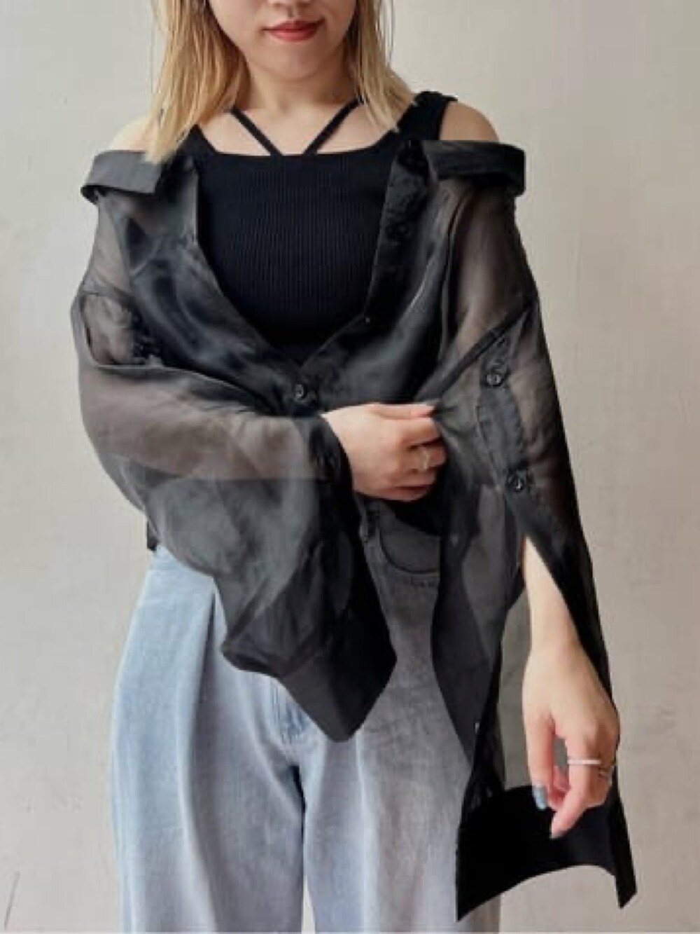 ブラック系のシャツ/ブラウス、ブルー系のデニムパンツを着用したレディースの春コーディネートの2枚目の写真