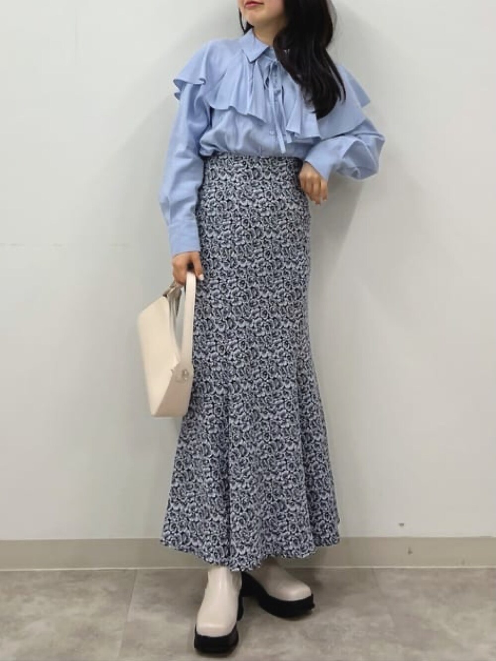 ホワイト系のブーツ、グレー系のスカート、ホワイト系のハンドバッグを着用したレディースの冬コーディネートの3枚目の写真