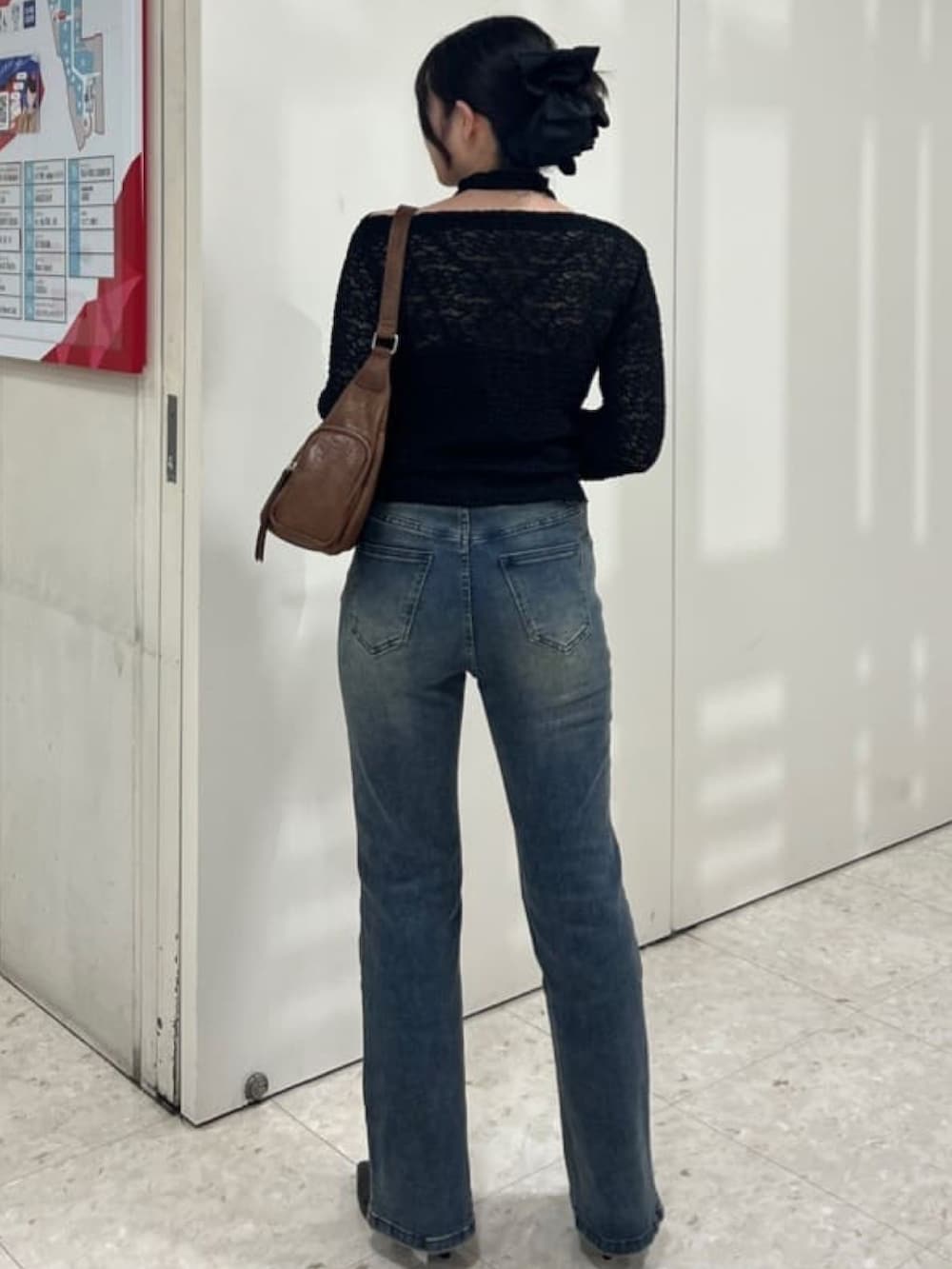 ブラック系のTシャツ/カットソー、ブルー系のデニムパンツ、ブラウン系のハンドバッグを着用したレディースの夏コーディネートの3枚目の写真