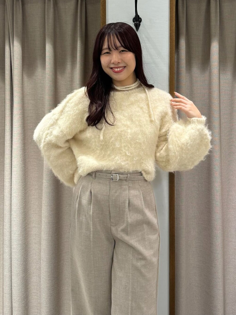 ブルー系のニット/セーター、ベージュ系のスラックスを着用したレディースの冬コーディネートの2枚目の写真