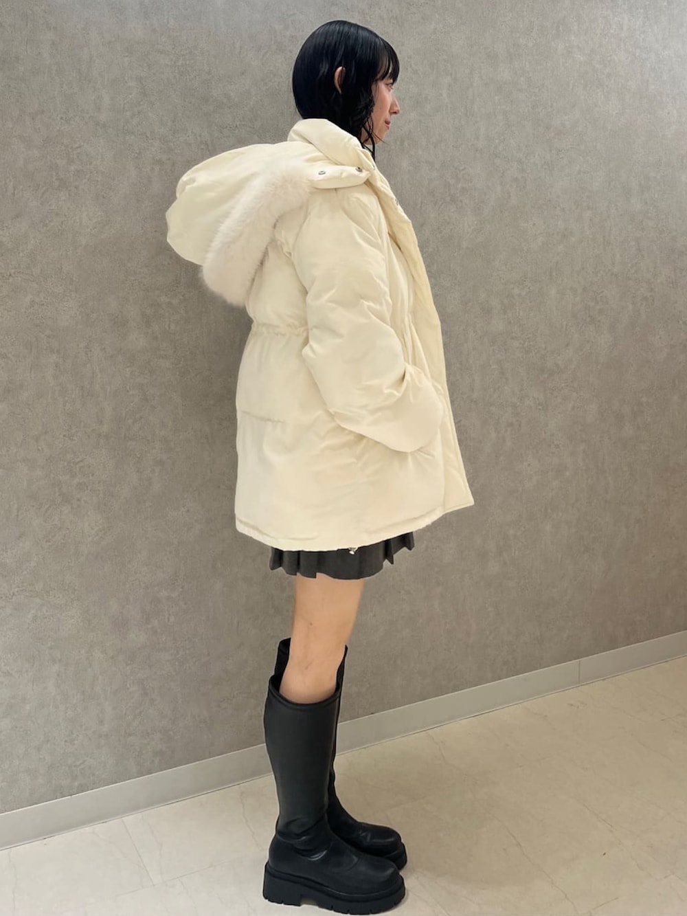 ブラック系のブルゾン、ホワイト系のニット/セーターを着用したレディースの冬コーディネートの2枚目の写真