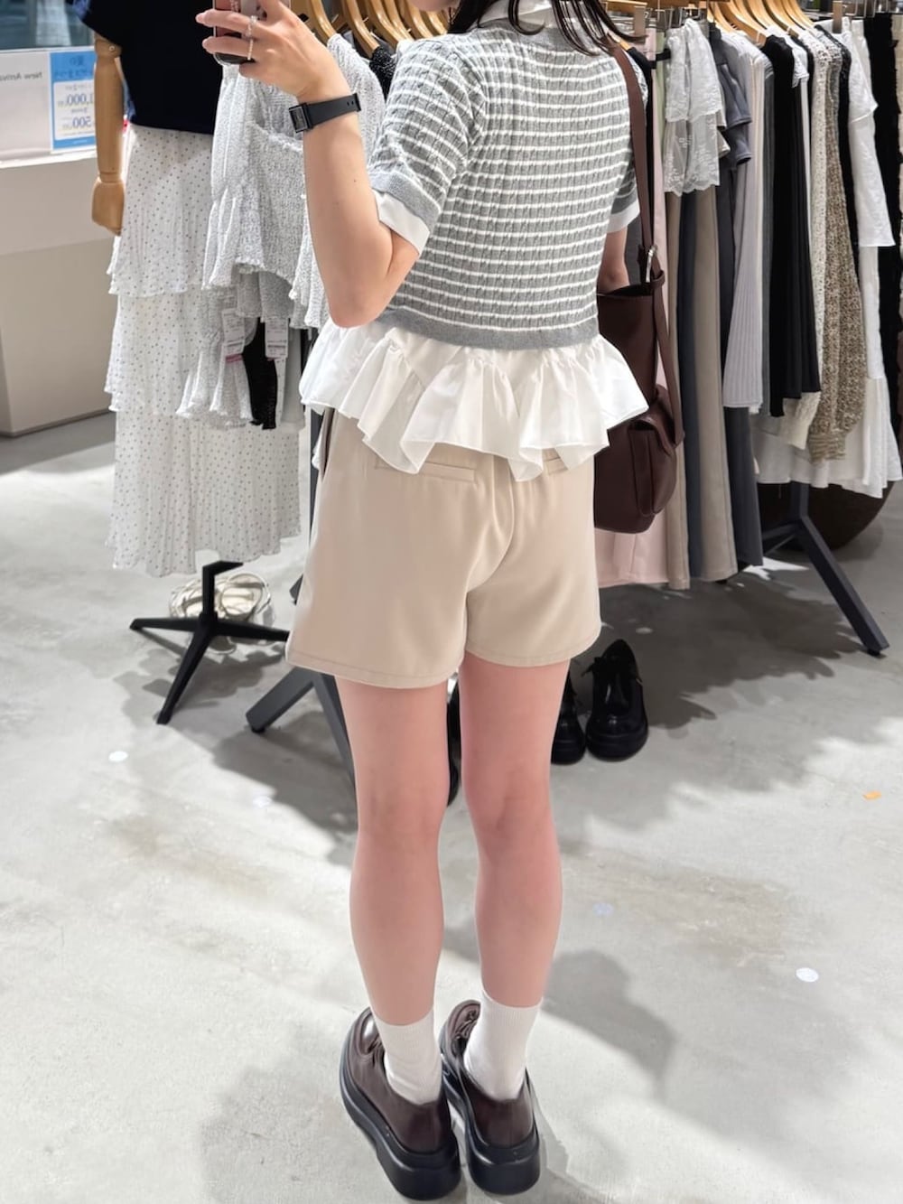 ベージュ系のその他パンツ、ホワイト系のニット/セーター、ブラウン系のパンプスを着用したレディースの夏コーディネートの3枚目の写真