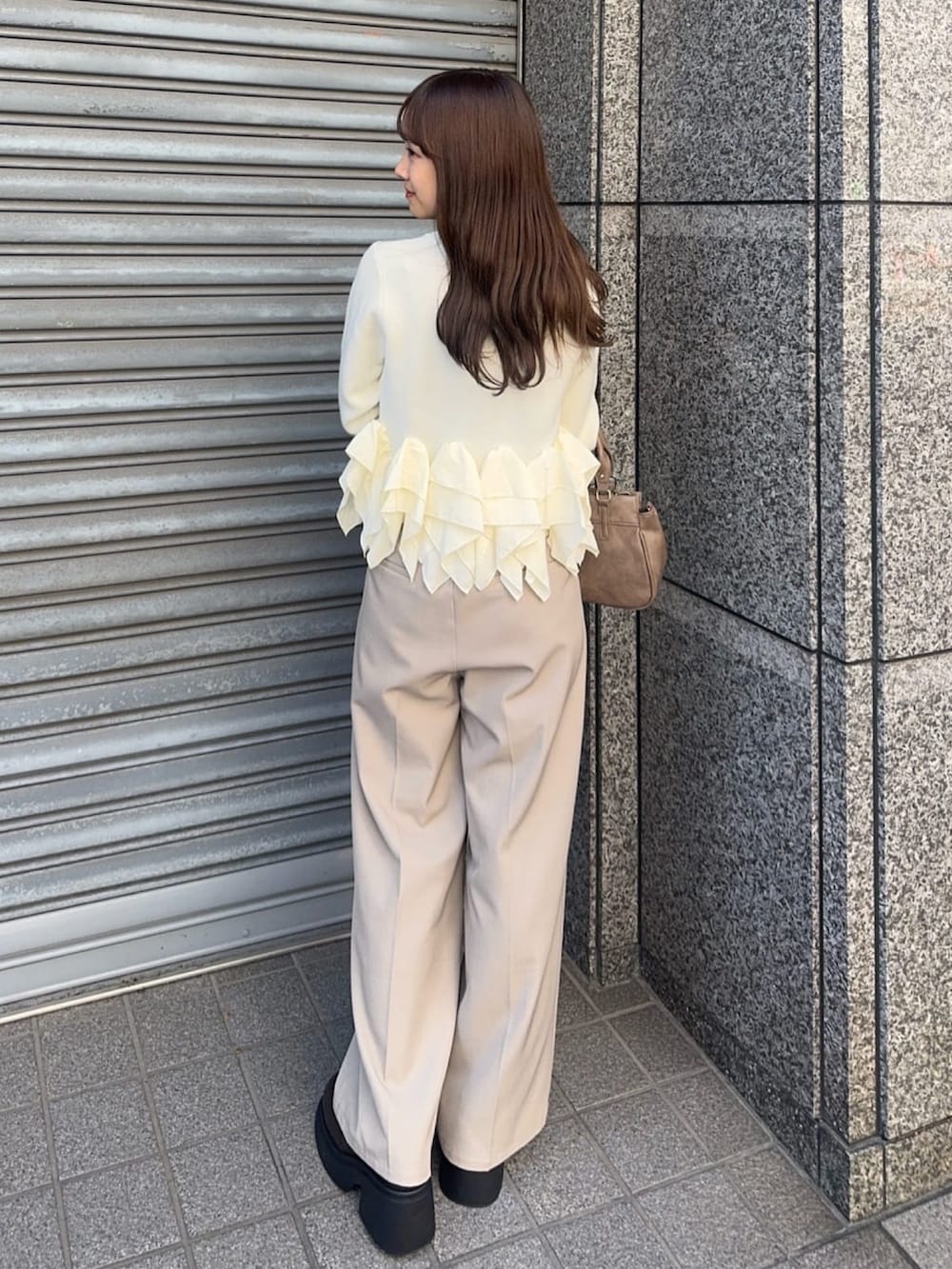 ベージュ系のニット/セーター、ブラウン系のパンプス、ブラウン系のショルダーバッグを着用したレディースの秋コーディネートの3枚目の写真