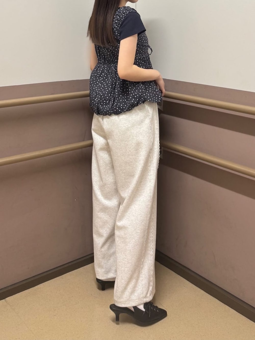 ベージュ系のスウェットパンツ、ブラック系のパンプス、ブラック系のTシャツ/カットソーを着用したレディースの夏コーディネートの2枚目の写真