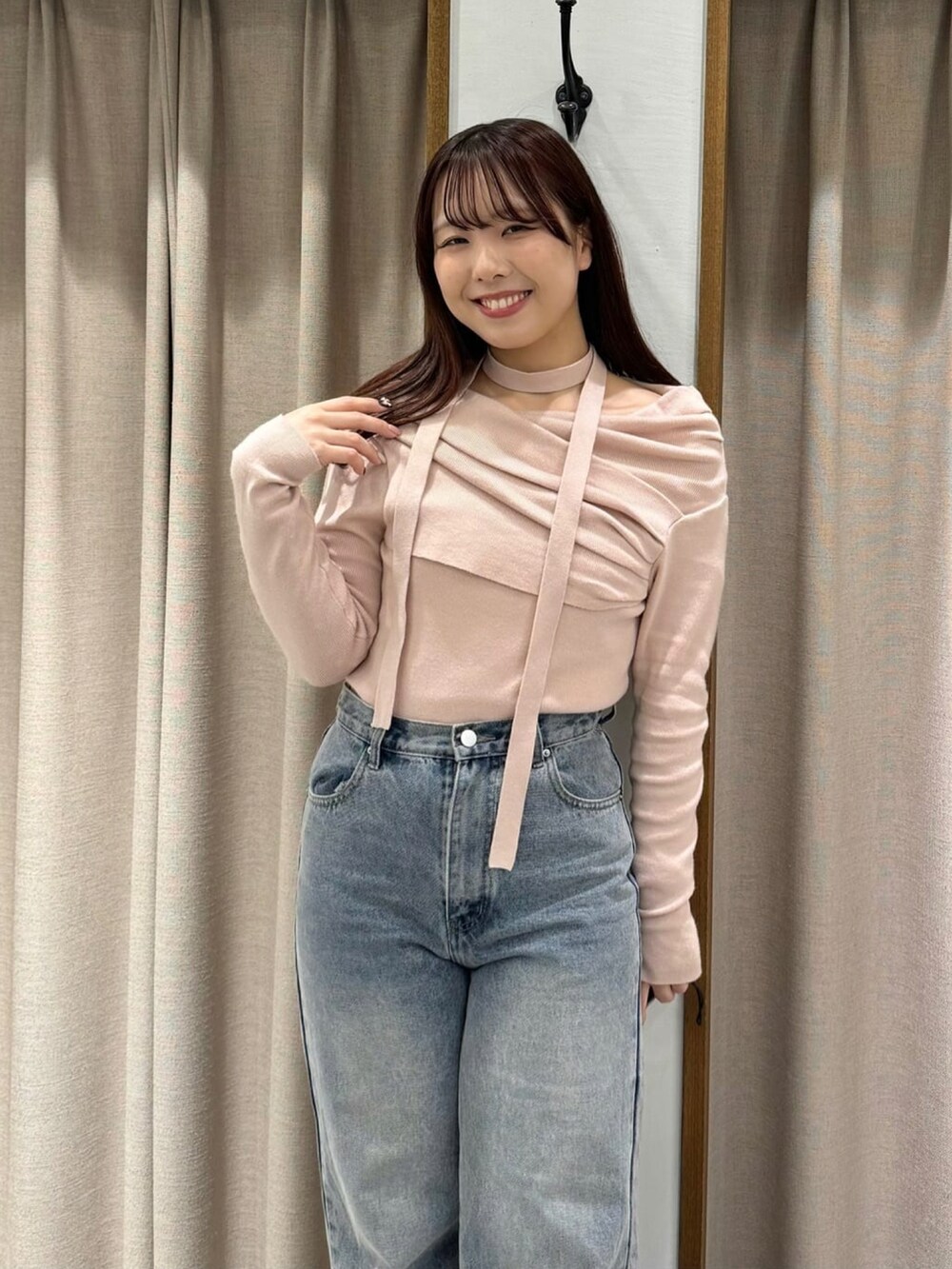 ピンク系のニット/セーター、ブルー系のデニムパンツを着用したレディースの冬コーディネートの2枚目の写真